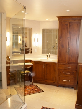 Custom cabinetry lines the bathroom featuring a makeup vanity, separate sink, and linen closet.