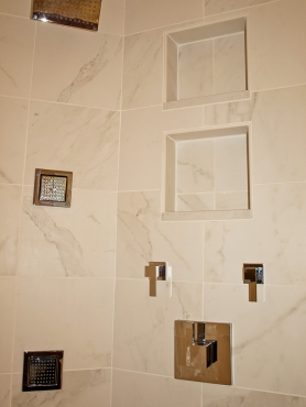 This walk in shower features recessed niche shelves using tile and Caesarstone. Separate volume and temperature controls by Grohe in a chrome finish.